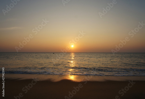 Southern tropical summer ocean coast at sunset. Lagoon with waves in which the sun is reflected. © Payllik