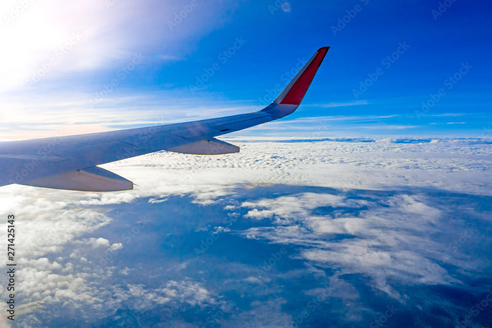 View from airplane window to see sky on Morning sunrise with Wing of an airplane.Into many white clouds. View from airplane window to see sky on Morning sunrise with Wing of an airplane.Into many white clouds.