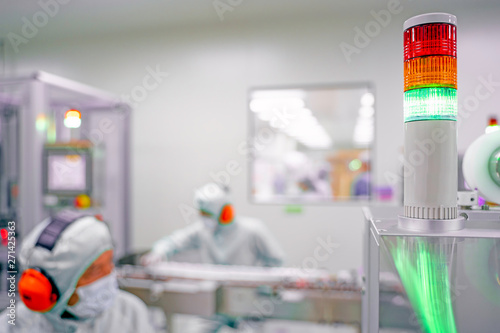 Warning light alarm for machine working In the pharmaceutical factory.Blur production staff are working in the background.
