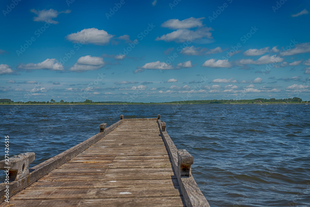 Fototapeta premium Old rickety wooden jetty leading into a lake