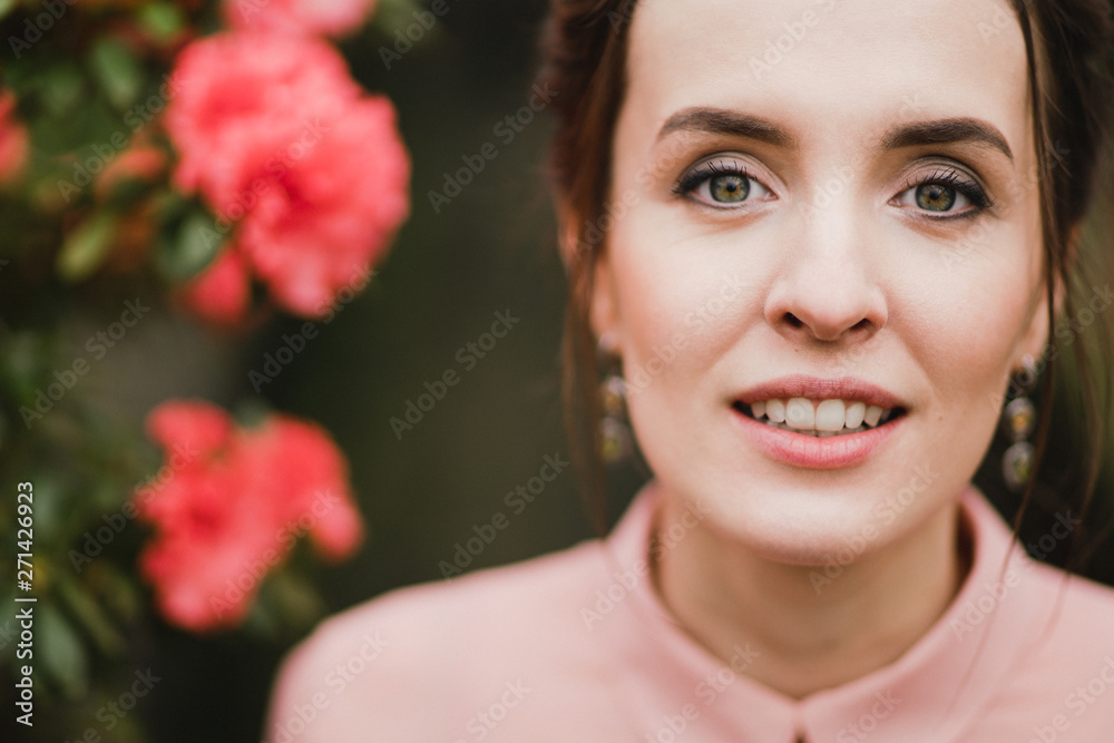Young beautiful caucasian woman in glass greenhouse among colorful azalea flowers. Art portrait of a girl wearing a romantic pink dress. Young beautiful caucasian woman in glass greenhouse among colorful azalea flowers. Art portrait of a girl wearing a romantic pink dress.