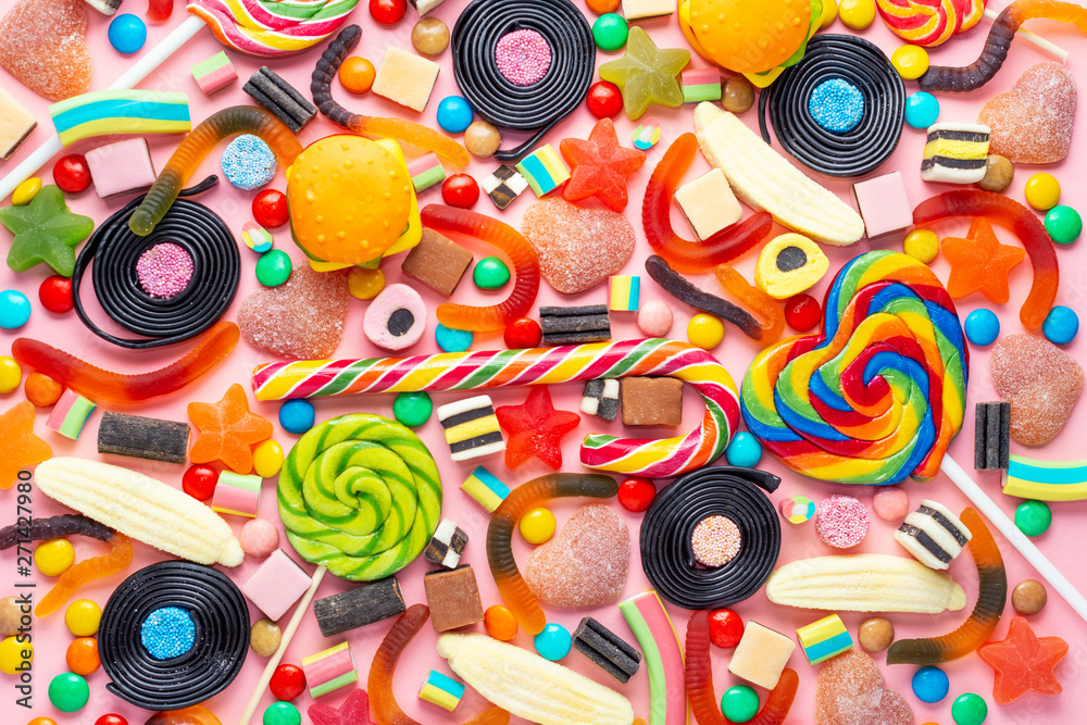 assortment of colourful lollipops, fruit bonbon and candies on pink like background assortment of colourful lollipops, fruit bonbon and candies on pink like background