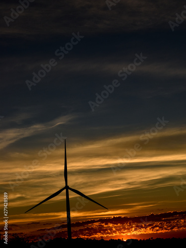 Silhouette wind turbines at sunset
