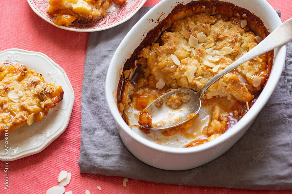 Overhead image of plum cobbler with almond flakes and cream Overhead image of plum cobbler with almond flakes and cream