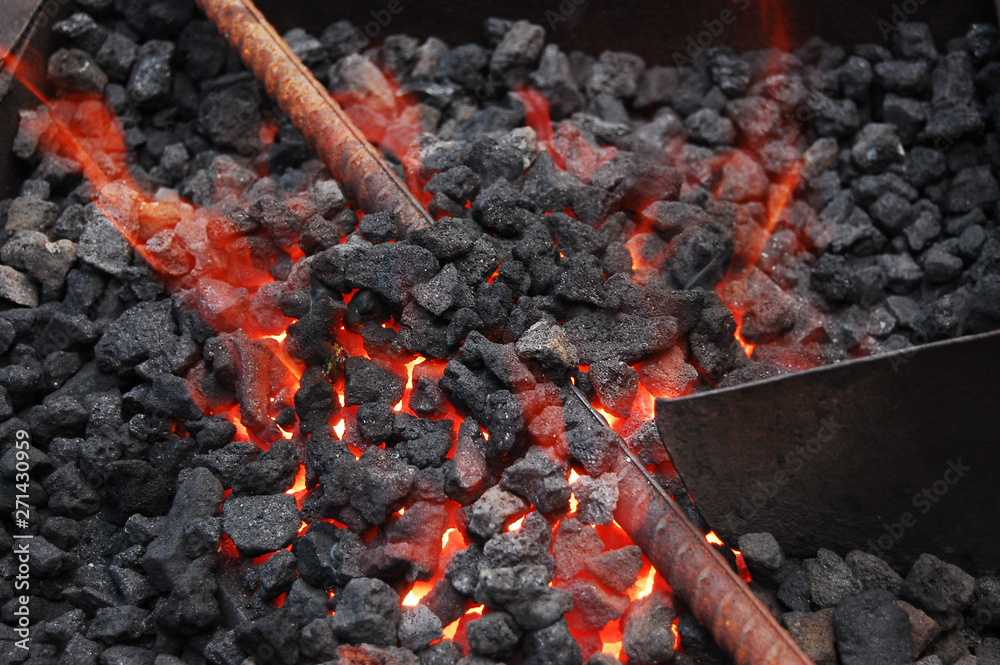 Metal bar being heated in coal furnance