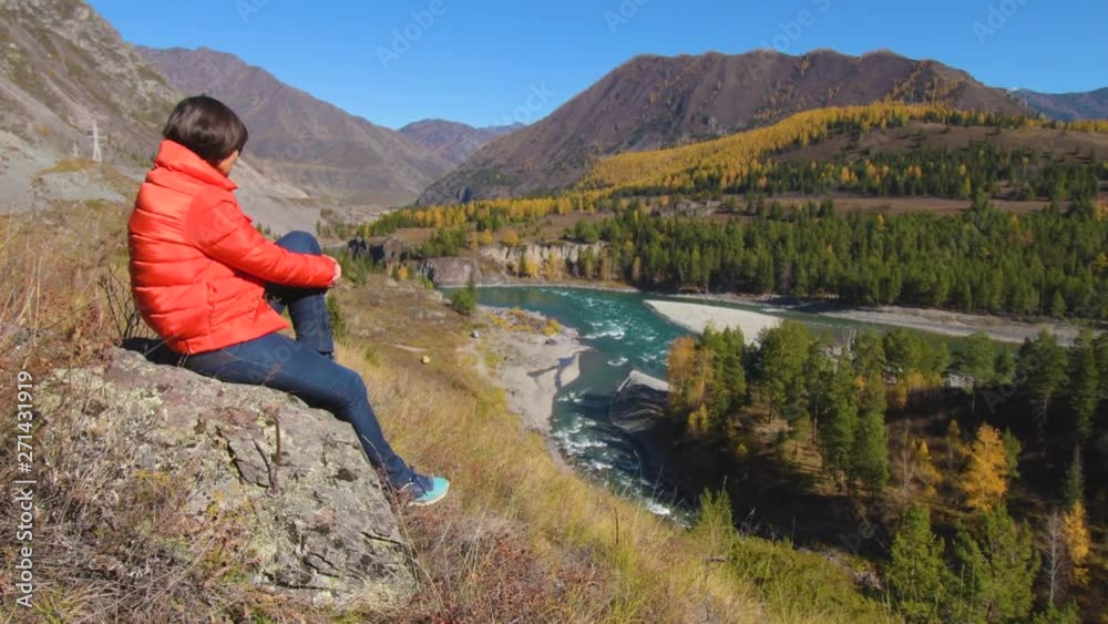 Woman traveler looking at natural canyon with view of the mountain river. Concept of travel. Woman traveler looking at natural canyon with view of the mountain river. Concept of travel.