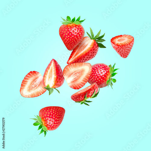 The composition of strawberries on a colored background. Cut strawberries into pieces with copy space. Fresh natural strawberry isolated