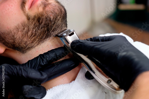 A barber attends to a customer in his barber shop