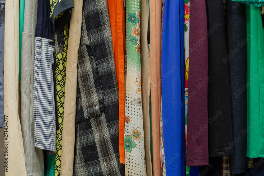 Beautiful colorful clothes in a store on hangers.