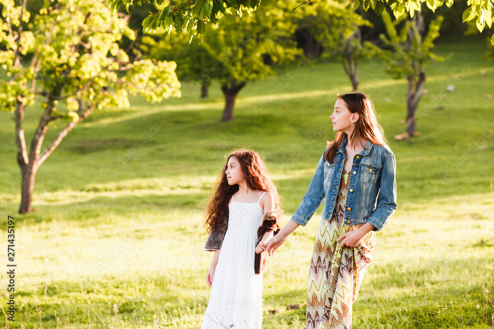 Two sisters in boho outfits are walking around the village. Beautiful, summer landscape. Country Holiday... Two sisters in boho outfits are walking around the village. Beautiful, summer landscape. Country Holiday...