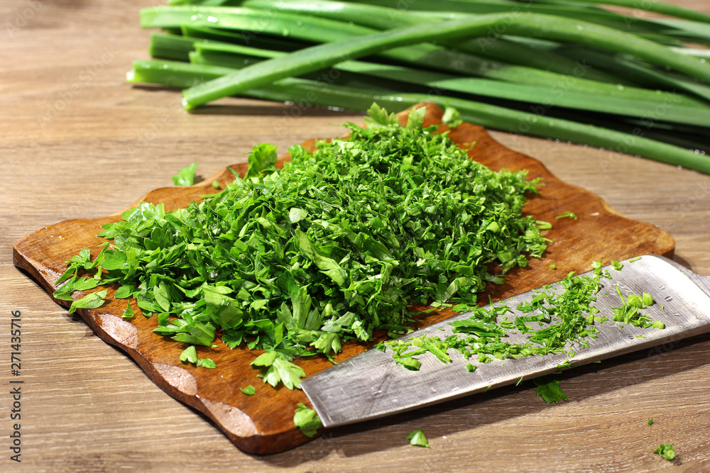 Cooking in the kitchen. Greenery. Green onions. Knife and cutting board Cooking in the kitchen. Greenery. Green onions. Knife and cutting board