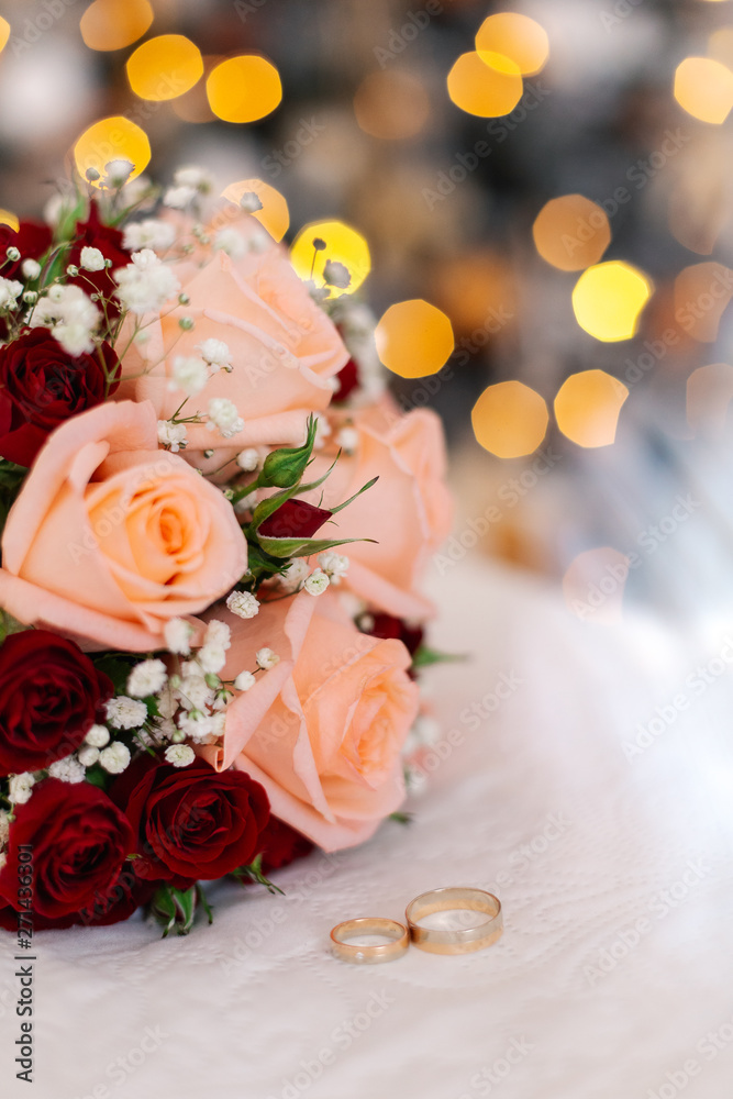 Beautiful fresh wedding bouquet with rings on a white bed. Beautiful fresh wedding bouquet with rings on a white bed.