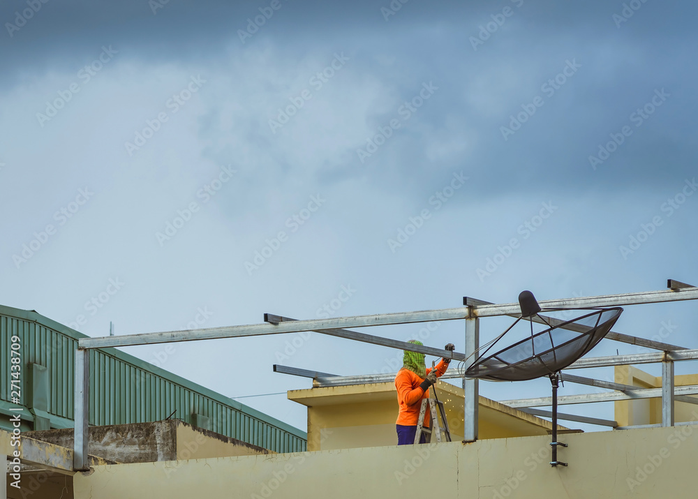 Worker welding the steel part for roof  before it is going to rain.