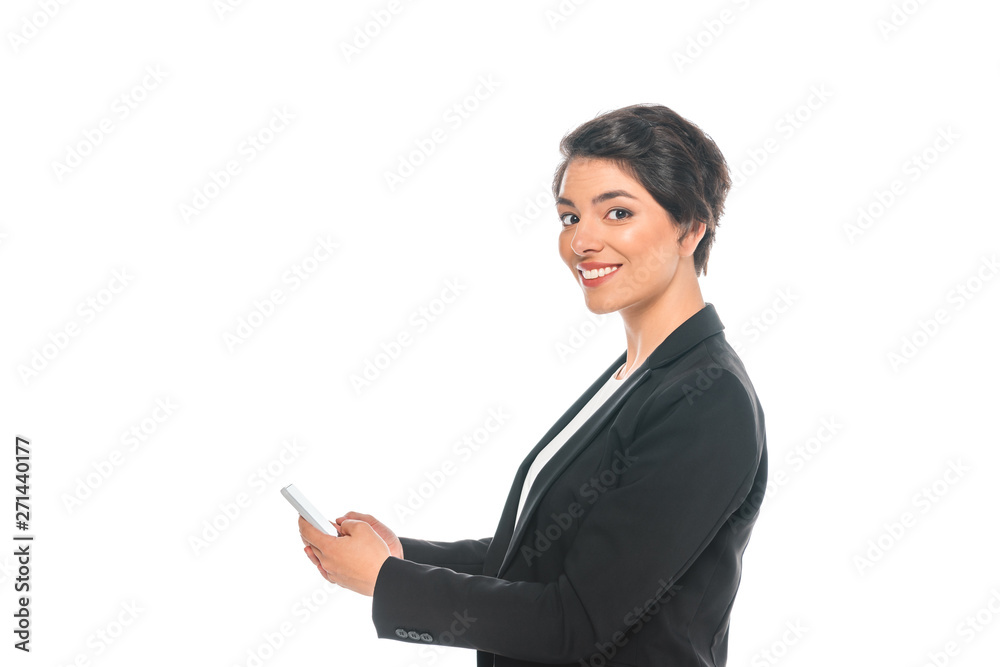 cheerful mixed race businesswoman using smartphone while smiling at camera isolated on white cheerful mixed race businesswoman using smartphone while smiling at camera isolated on white
