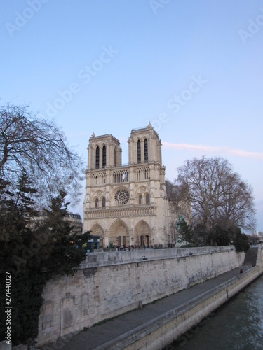 View of the Notre Dame cathedral at sunset with many tourists