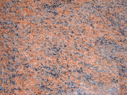 Background red natural granite stone. Black and light blotches and patterns. Texture. Polished surface with a crystalline structure. © Sergei Tim