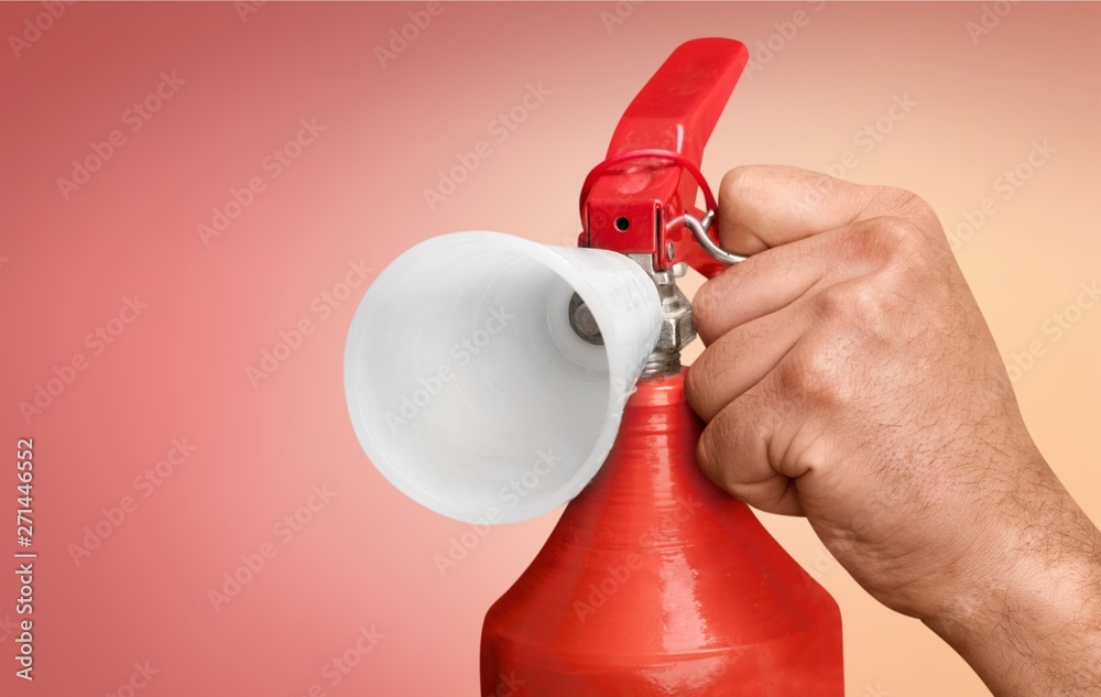 Naklejka premium Man using fire extinguisher against grey background