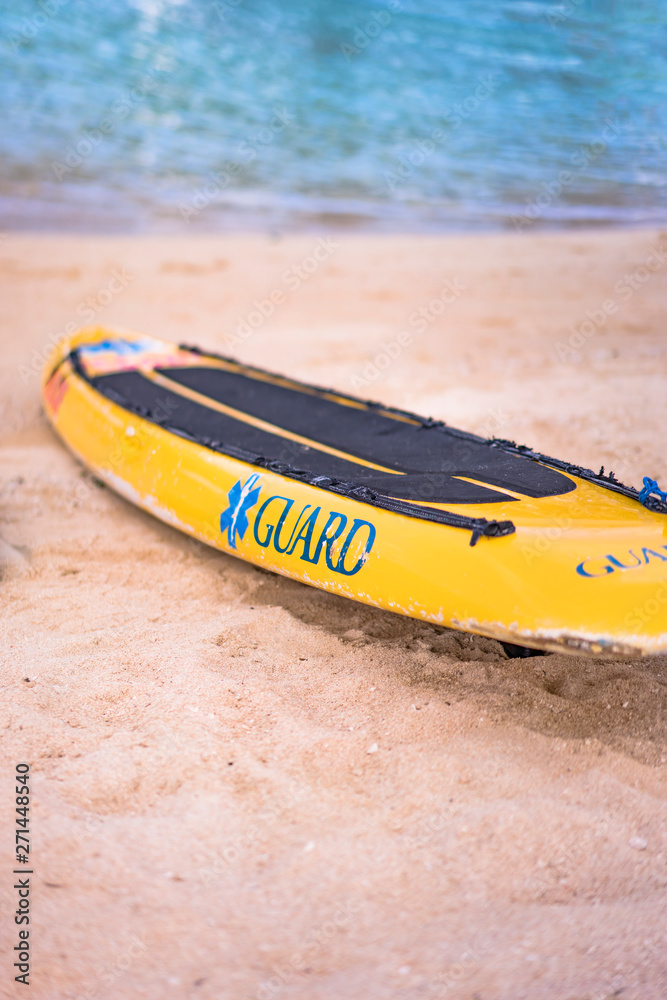 Lifeguard yellow board and buoy on the sandy beach Naminoue in Naha City in Okinawa Prefecture, Japan. Lifeguard yellow board and buoy on the sandy beach Naminoue in Naha City in Okinawa Prefecture, Japan.