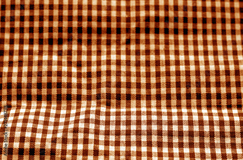 Checked fabric texture in blur effect in orange tone.