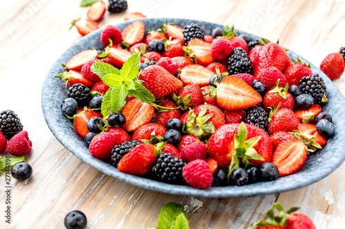 Draufsicht von frischen reifen Erdbeeren  von Blaubeeren und von Brombeeren auf Holztisch mit freiraumraum