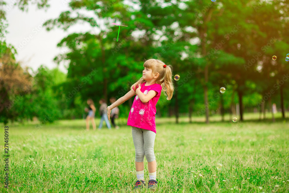Little girl playing on the meadow on sun with windmill in her hands. Child holding wind toy on wheat field. Little girl playing on the meadow on sun with windmill in her hands. Child holding wind toy on wheat field.
