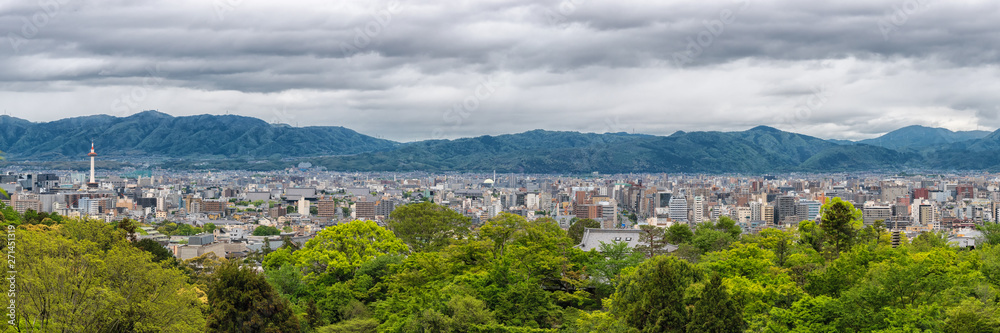 Panoramic Cityscape overview of Kyoto, Japan. Mountains and rainy sky at the background