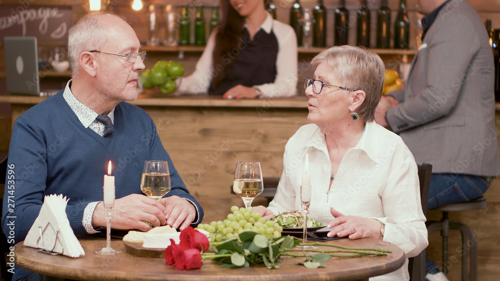 Old couple sitting at the table in a restaurant and drinking wine Stock  Photo | Adobe Stock