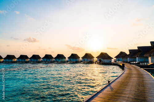 Fototapeta Naklejka Na Ścianę i Meble -  Beautiful tropical sunset over Maldives island with water bungalow in hotel resort