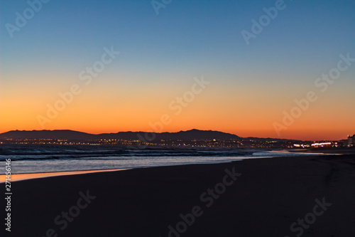 Beach and city lights at sunset