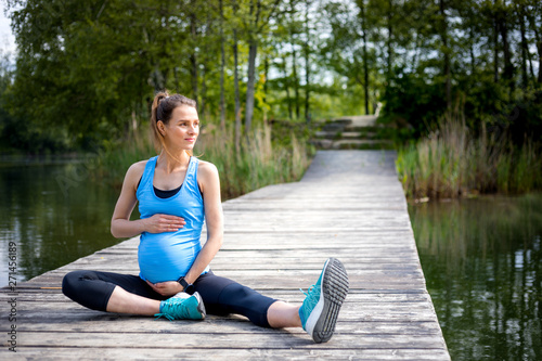 Fototapeta Naklejka Na Ścianę i Meble -  Pregnant woman exercising outdoor and resting