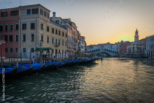 Row of gondolas and Rialto bridge in the background at the morning  Venezia  Italy