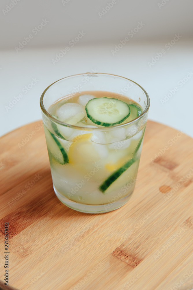 glass of water with cucumber on wooden background glass of water with cucumber on wooden background
