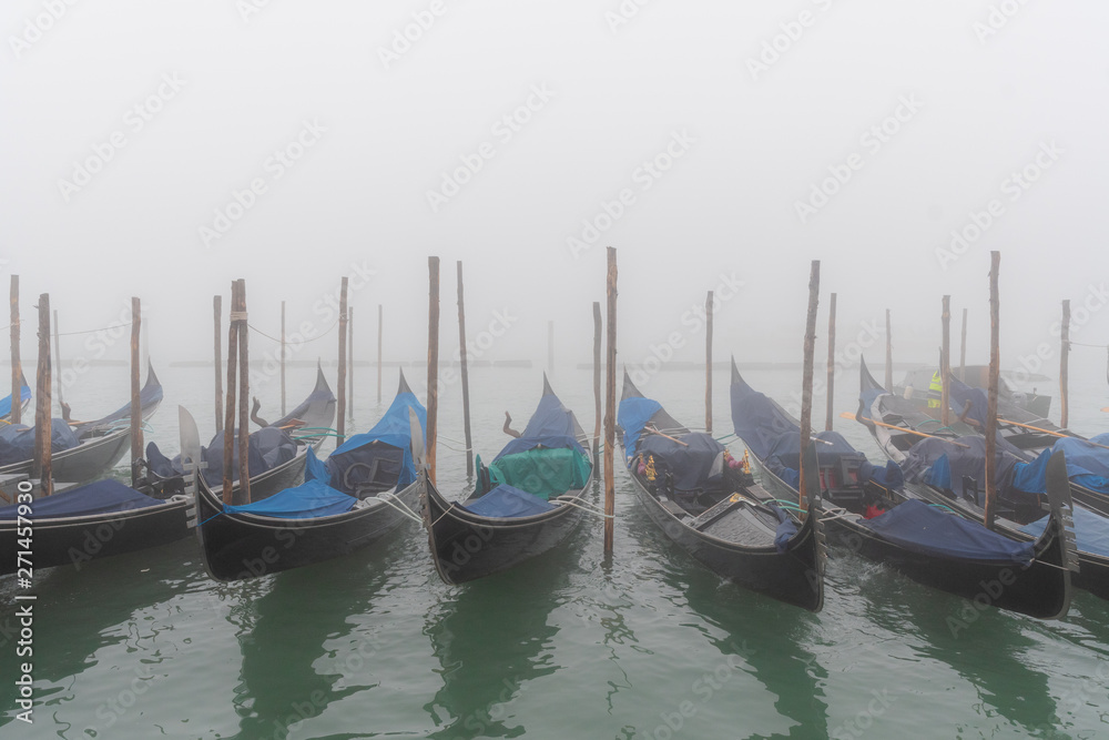 Row of gondolas in the laguna with fog in the winter, Venezia, Italy
