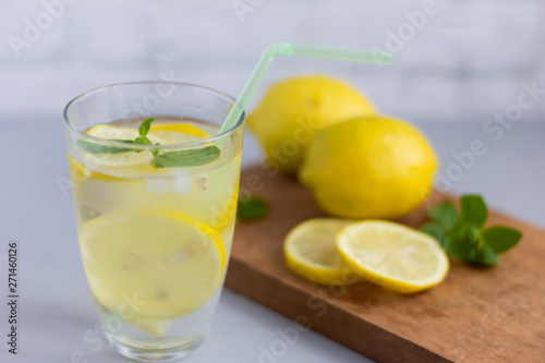 water in a glass with lemon and oregano leaves,a refreshing soft drink to quench your thirst in the heat and maintain tone