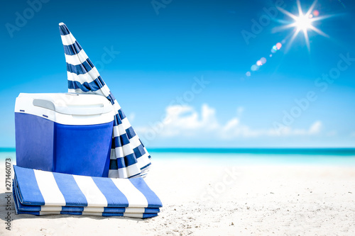 Summer time on beach and blue beach fridge on sand. Ocean landscape and sunny day. 