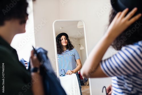Valokuva Female friends trying on clothes indoors, house sharing concept.