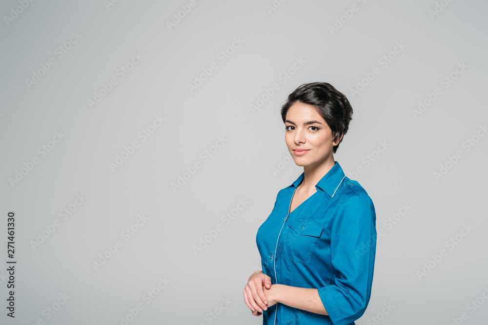 beautiful mixed race nurse in uniform looking at camera isolated on grey beautiful mixed race nurse in uniform looking at camera isolated on grey