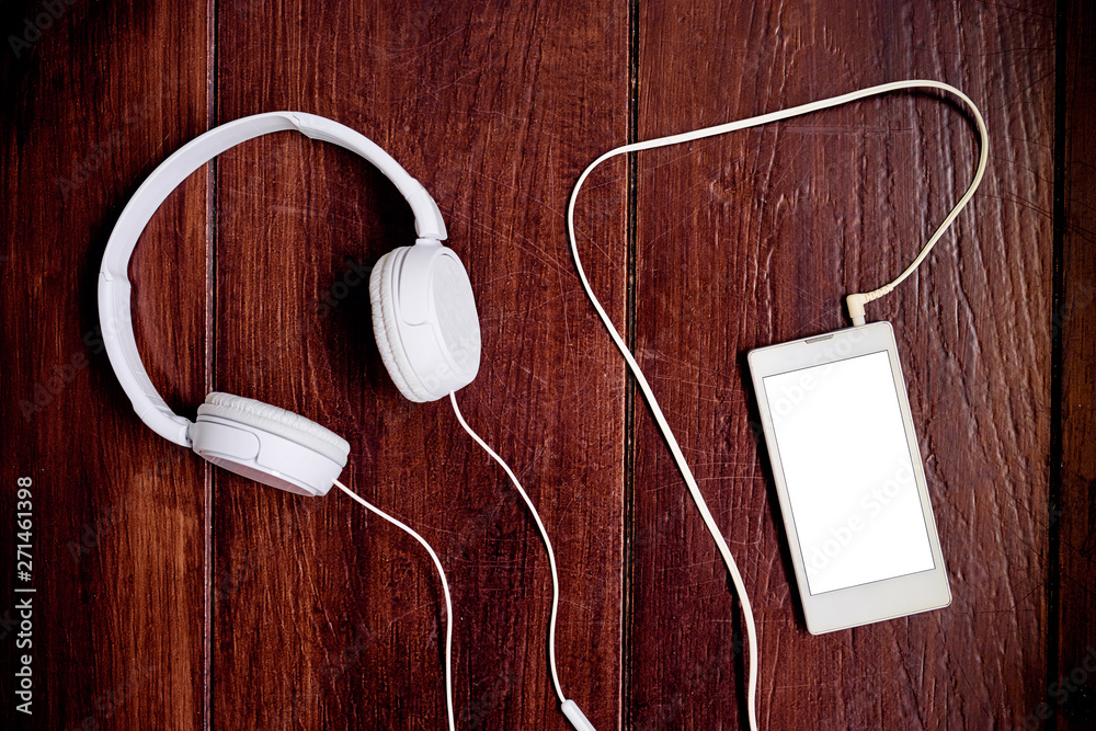 Music and technology. Earphones and smartphone on wooden background. Music and technology. Earphones and smartphone on wooden background.