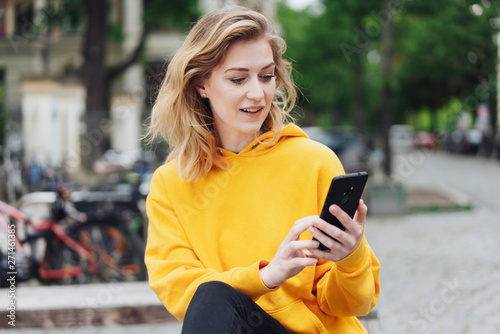frau ist in der stadt unterwegs und tippt eine nachricht auf ihrem handy