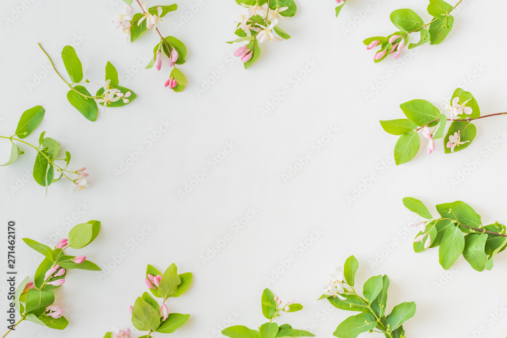 Flat lay pattern with branches and green leaves on a white background