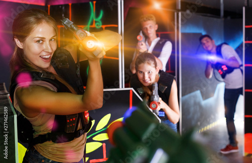 men and women playing emotionally laser tag game in arena