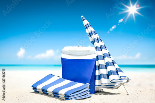 Summer time on beach and blue beach fridge on sand. Ocean landscape and sunny day. 
