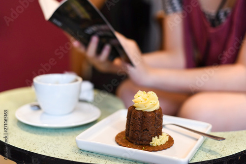 cake with a cup of coffee and someone reading a book