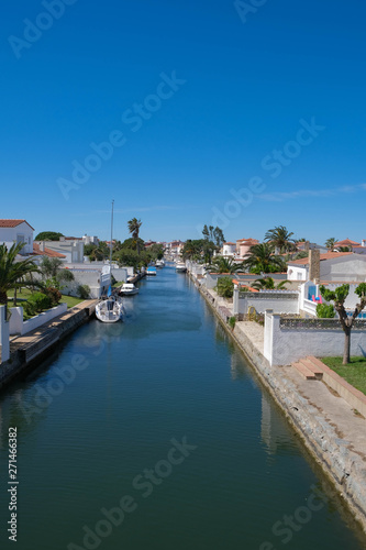 Amazing view on marine canal with boats and white houses. Resort town landscape with palm trees, little Spanish Venice, Empuriabrava. Rich lifestyle, Summertime, calm scene. Perfect vacations.