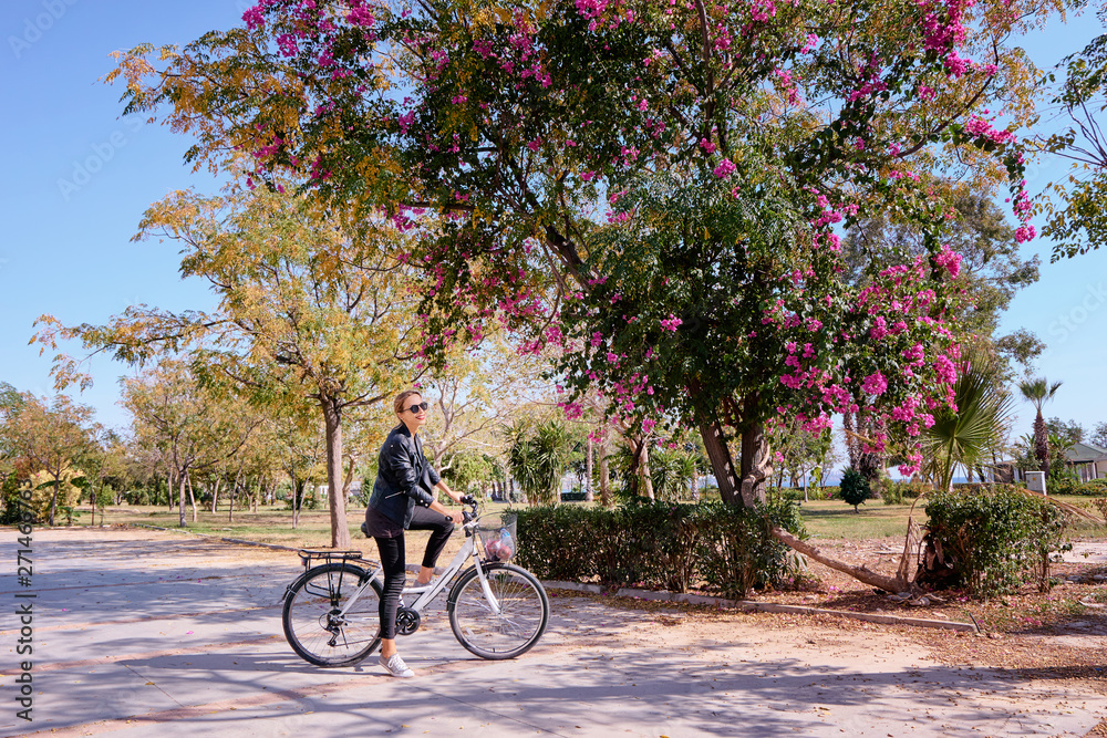 Young woman riding bicycle in park.