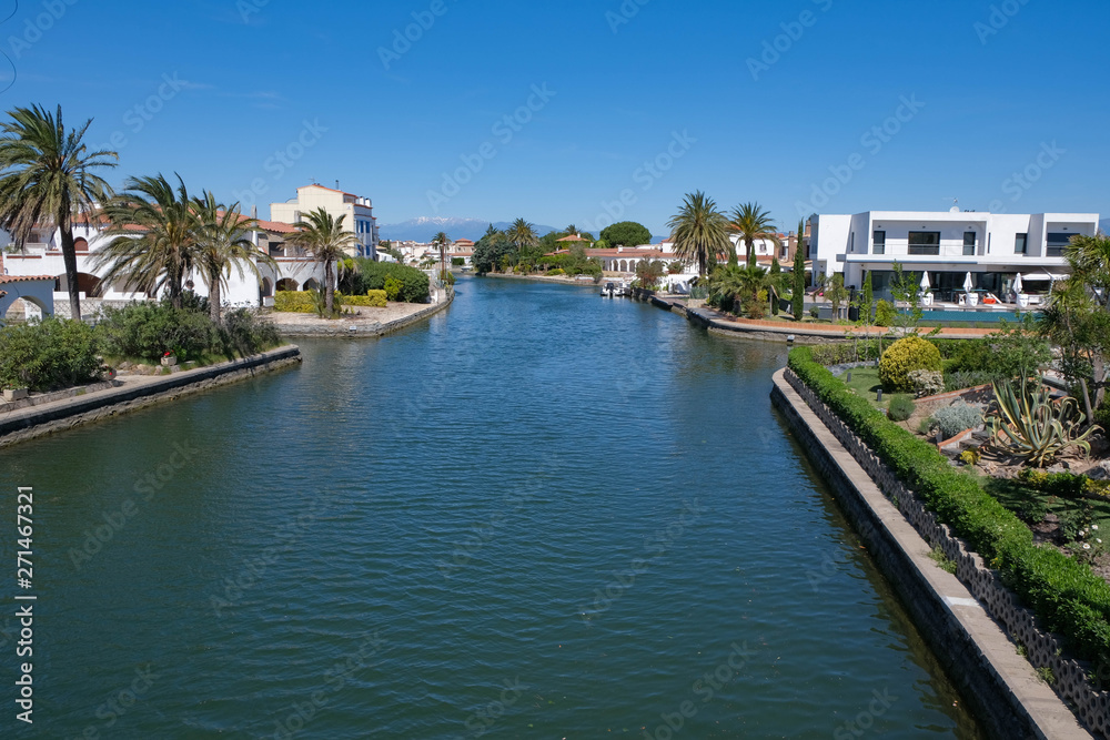 Amazing view on marine canals with expensive white houses . Beautiful Resort town landscape with palm trees, little Spanish Venice, Empuriabrava. Rich lifestyle, Summer time.