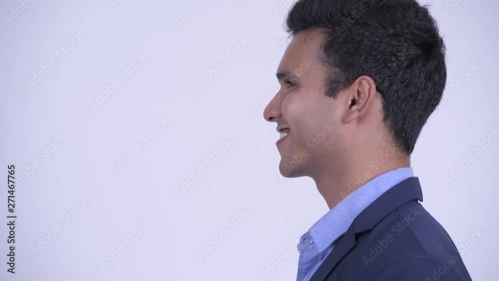 Closeup profile view of happy young Indian businessman smiling Closeup profile view of happy young Indian businessman smiling