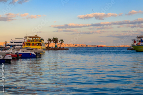 White yachts in the sea harbor of Hurghada, Egypt. Port with tourist boats on the Red Sea © olyasolodenko