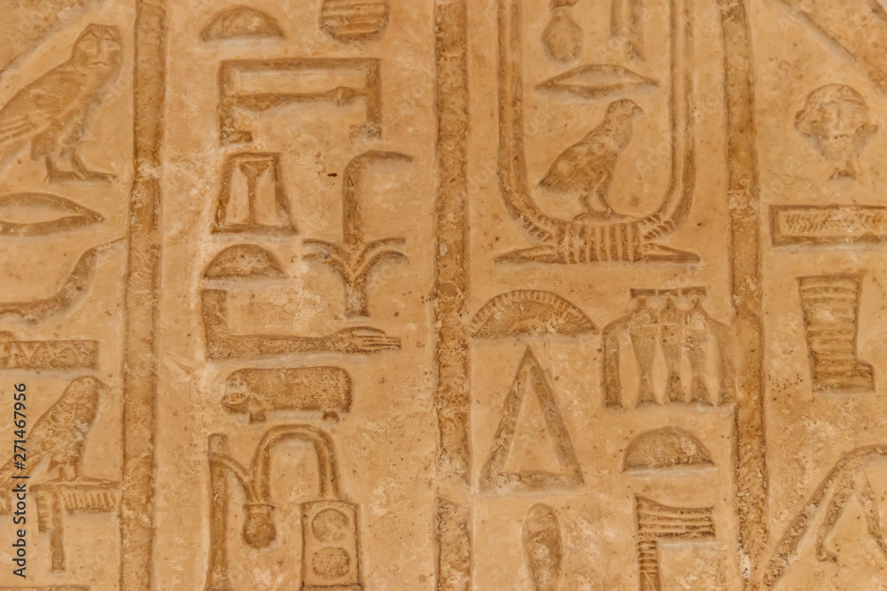 Ancient egyptian hieroglyphs carved on the stone wall