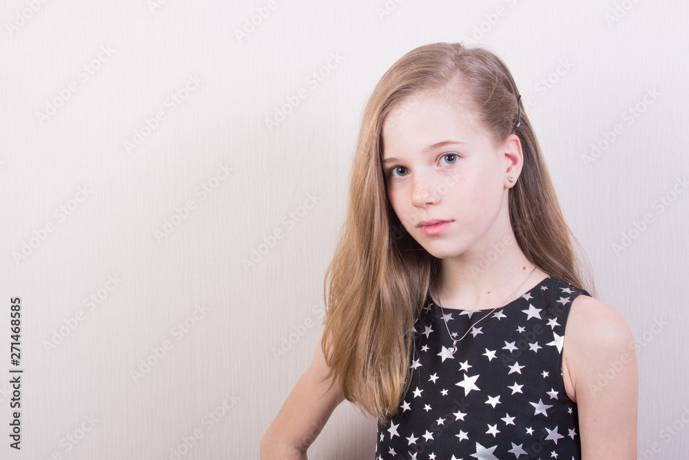 Portrait of a young girl with light brown hair in a black dress with silver stars Portrait of a young girl with light brown hair in a black dress with silver stars